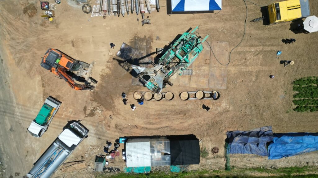 Drill rig, the row of DTH hammers under test and the buried cylinders