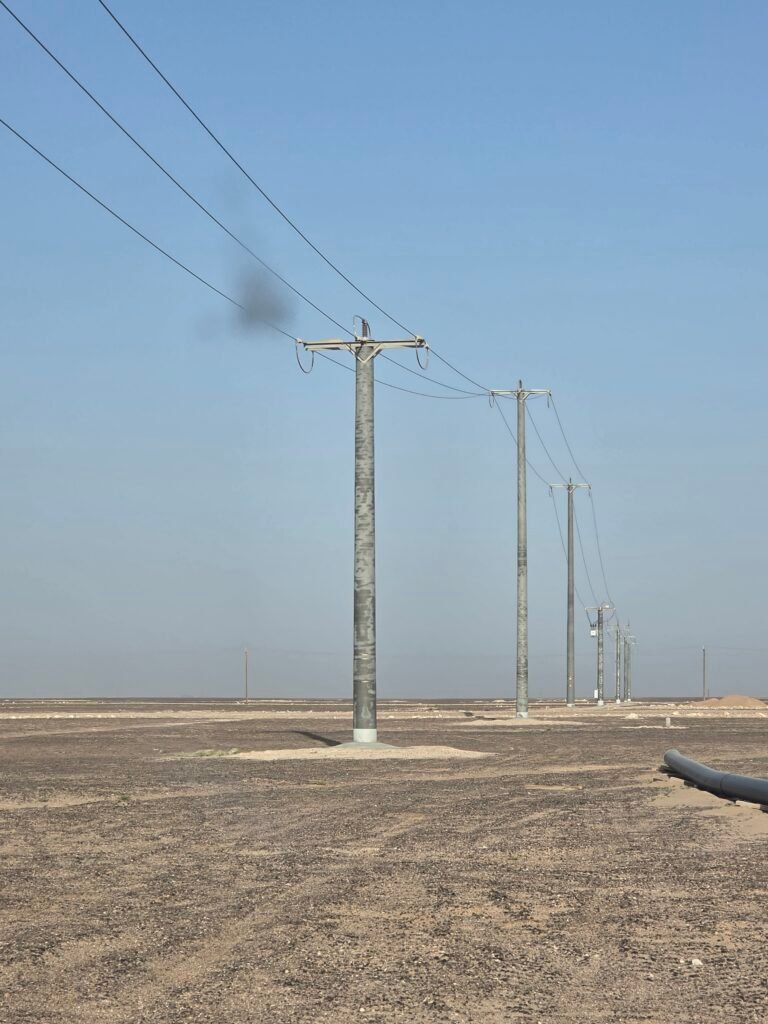 Completed 33 kV overhead line on spun concrete pole foundations across a desert oilfield