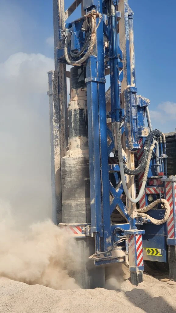 Ø1,000 mm DTH bit entering the hole with cuttings blown clear by the flushing air